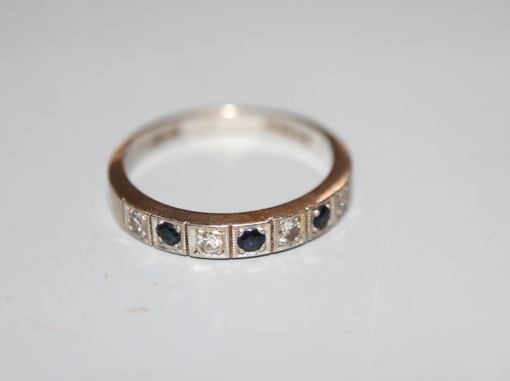 A modern 18ct white gold, sapphire and diamond set seven stone half hoop ring, size N, gross 3.7 grams.